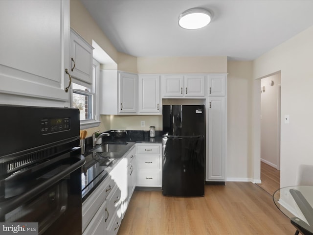 kitchen with sink, light hardwood / wood-style floors, white cabinetry, and black appliances