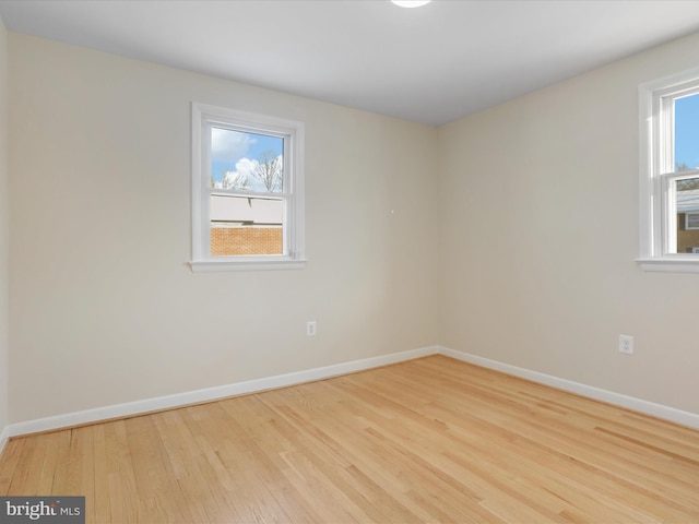 spare room featuring light hardwood / wood-style floors and a wealth of natural light