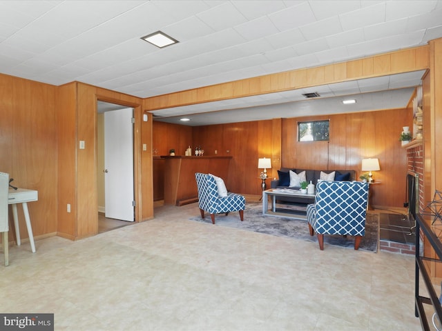 living room with wooden walls and a fireplace