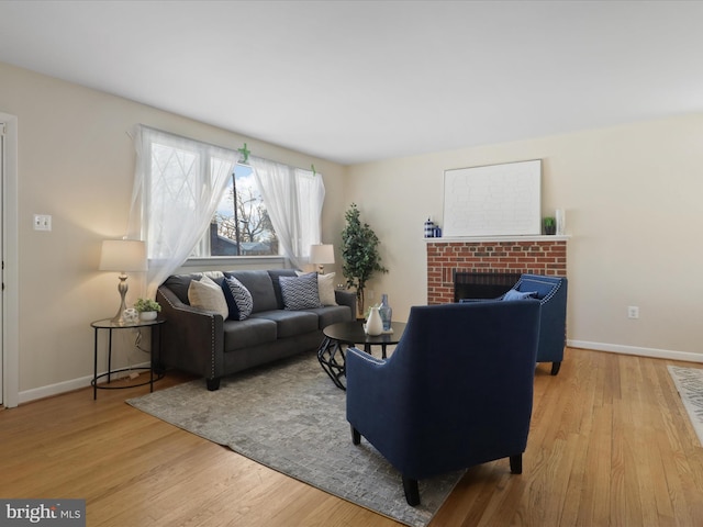 living room featuring light hardwood / wood-style floors and a brick fireplace