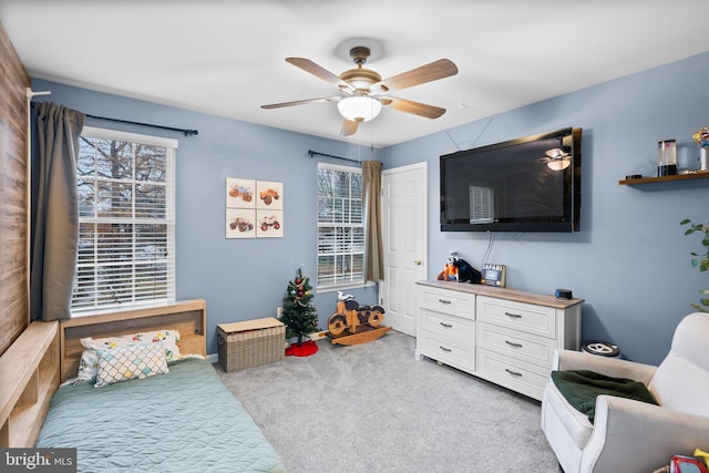 carpeted bedroom with ceiling fan and multiple windows