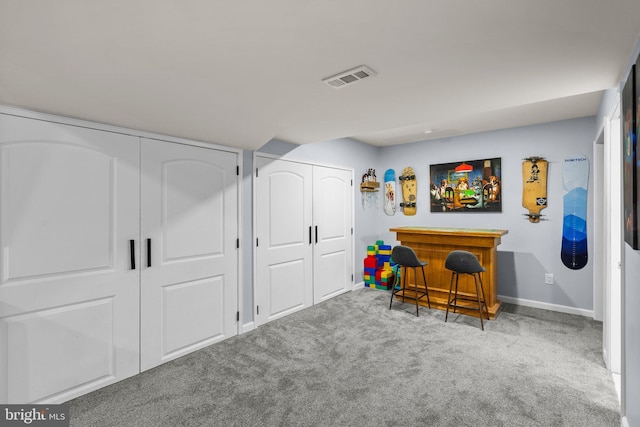 interior space featuring light colored carpet and indoor bar