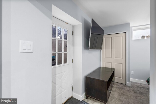 doorway featuring dark colored carpet