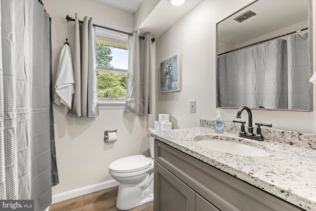 bathroom featuring wood-type flooring, vanity, and toilet