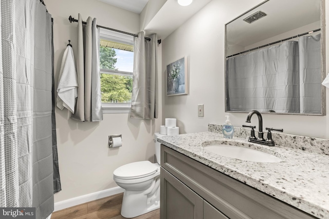 bathroom with vanity, hardwood / wood-style flooring, and toilet