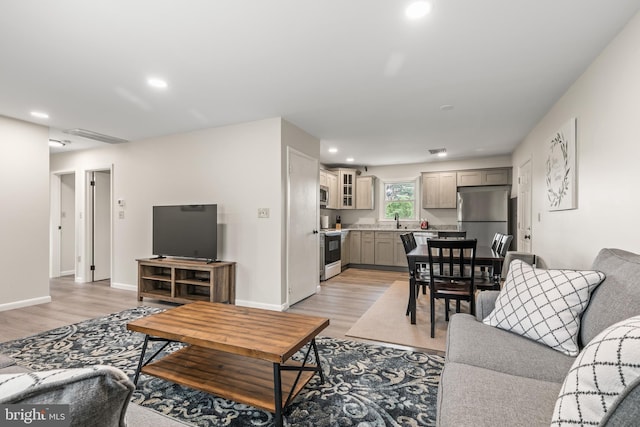 living room with sink and light hardwood / wood-style flooring