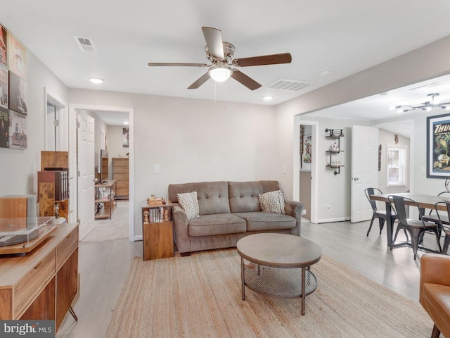 living room featuring light hardwood / wood-style flooring and ceiling fan