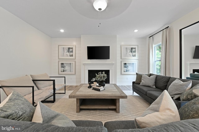 living room with ceiling fan and light hardwood / wood-style flooring