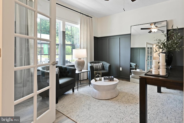 living area featuring ceiling fan, light hardwood / wood-style floors, and french doors