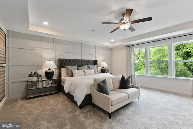 bedroom featuring a tray ceiling, ceiling fan, and carpet flooring