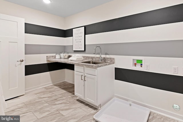 kitchen featuring white cabinetry and sink