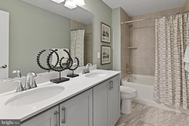 full bathroom featuring shower / bath combination with curtain, vanity, a textured ceiling, and toilet