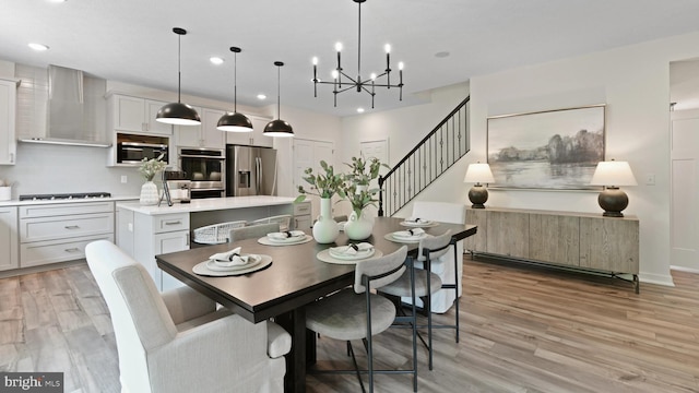 dining area featuring light wood-type flooring and a notable chandelier