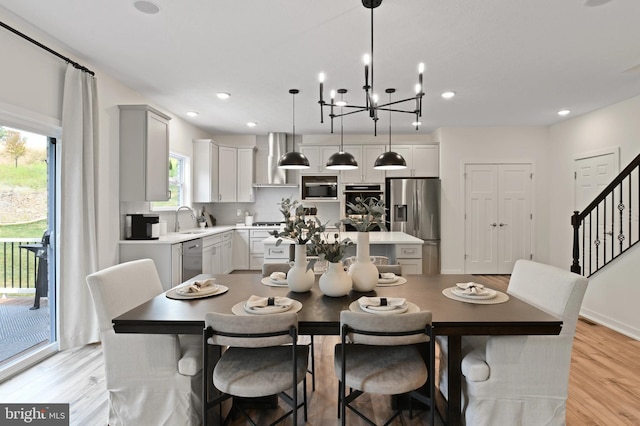 dining space featuring a wealth of natural light, sink, light hardwood / wood-style floors, and an inviting chandelier