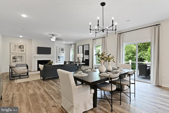8 Timberidge Dr, Fredericksburg, VA 22406 - dining area featuring light wood-type flooring, a fireplace with raised hearth, a chandelier, recessed lighting, and a ceiling fan