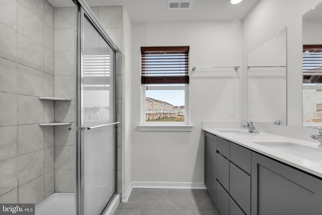 bathroom with tile patterned flooring, vanity, and a shower with shower door