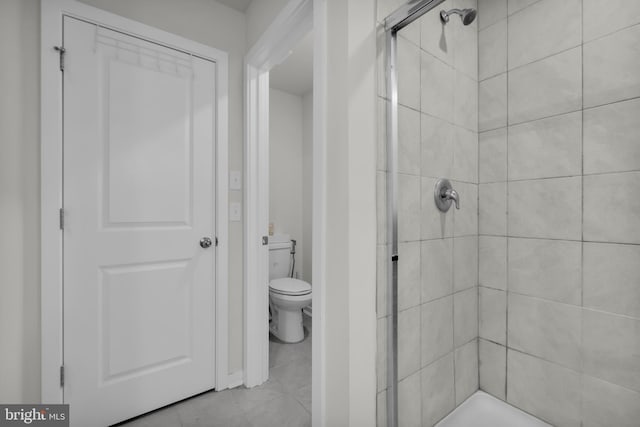 bathroom featuring toilet and a shower with shower door