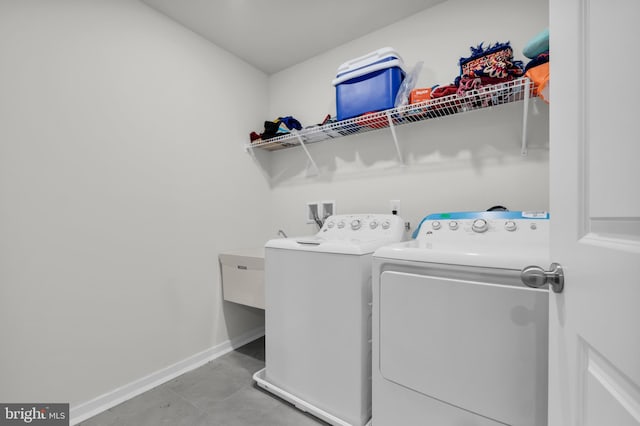 clothes washing area featuring tile patterned flooring and washer and dryer