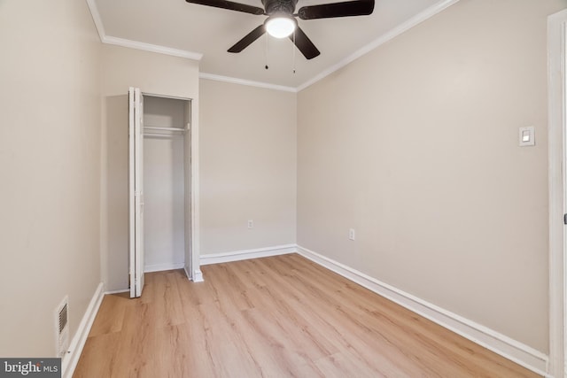 unfurnished bedroom featuring a closet, light hardwood / wood-style flooring, ceiling fan, and ornamental molding