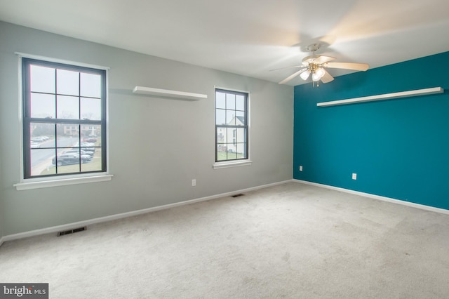 carpeted spare room with ceiling fan and a healthy amount of sunlight