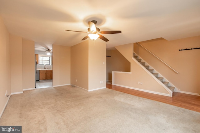 unfurnished living room with light carpet and ceiling fan