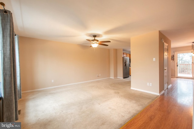 unfurnished living room featuring ceiling fan and light wood-type flooring