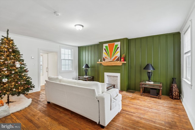 living room with wood-type flooring and ornamental molding