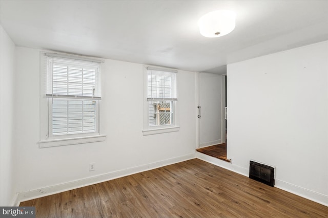 unfurnished room with a wealth of natural light and dark wood-type flooring