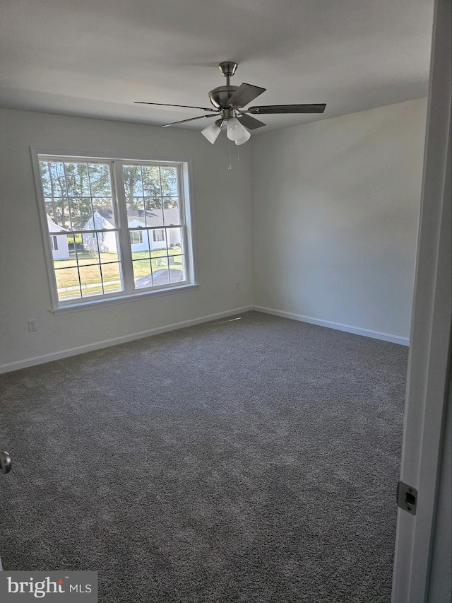 carpeted spare room featuring ceiling fan