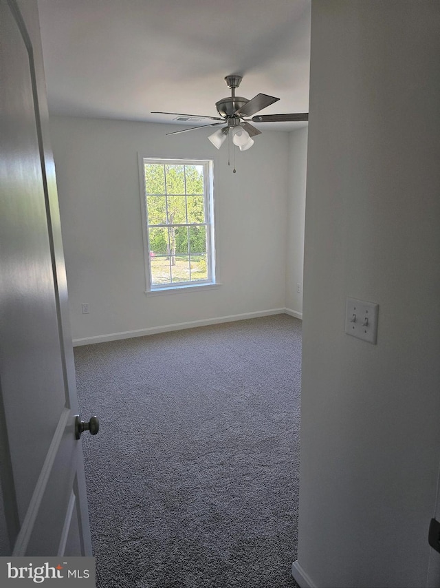 carpeted spare room with ceiling fan