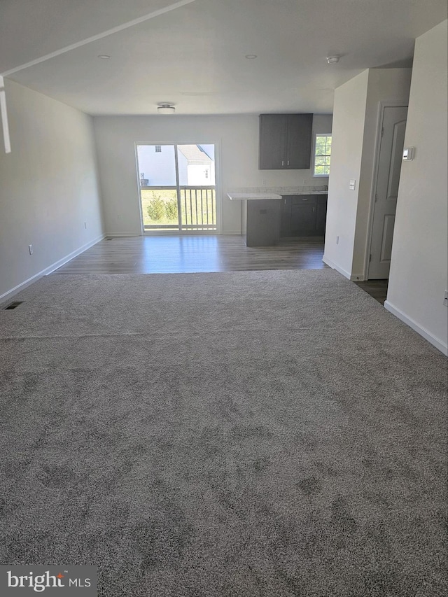 unfurnished living room with dark colored carpet