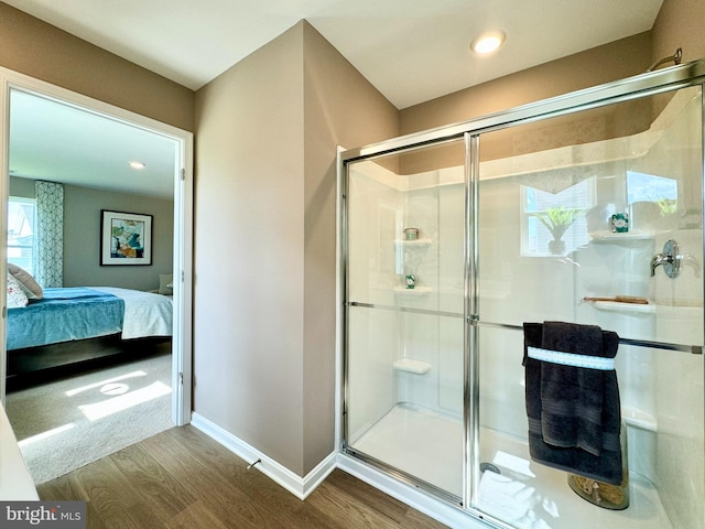 bathroom with hardwood / wood-style flooring and a shower with door