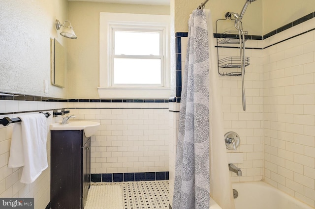 bathroom with shower / bath combination with curtain, vanity, and tile walls