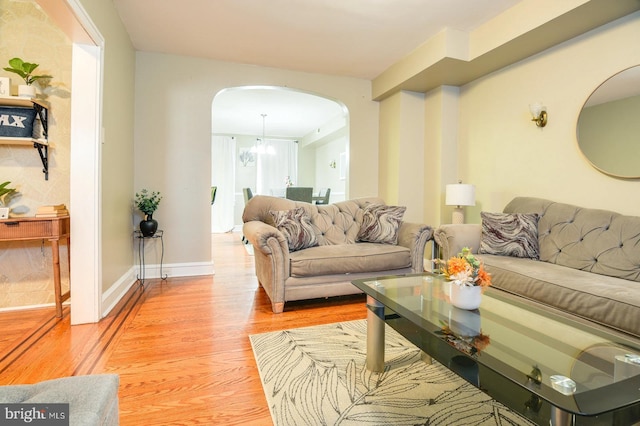 living room with a notable chandelier and light hardwood / wood-style floors