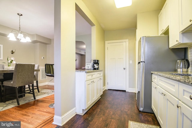 kitchen with white cabinets, dark hardwood / wood-style floors, and light stone counters