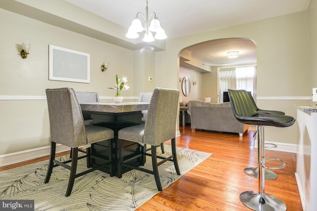 dining room with an inviting chandelier and light hardwood / wood-style flooring