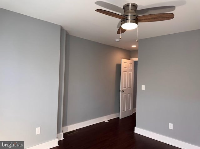 empty room with ceiling fan and dark hardwood / wood-style flooring