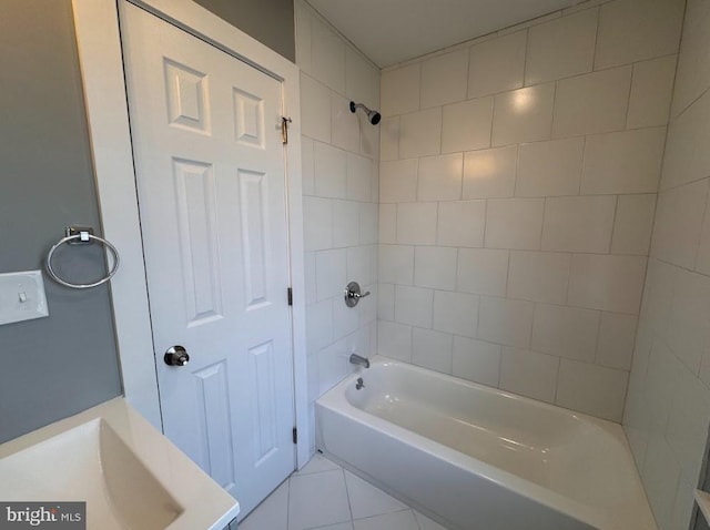 bathroom with tiled shower / bath combo, tile patterned floors, and sink