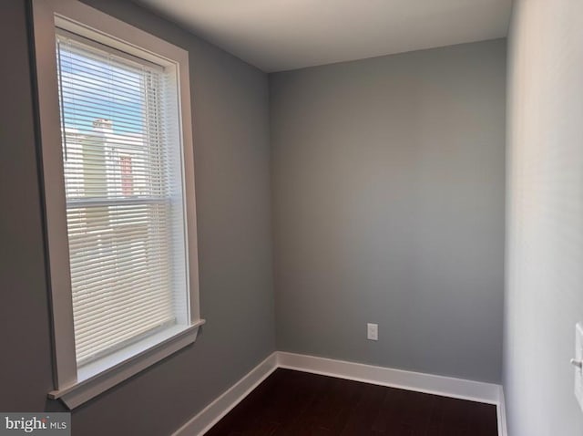 empty room with dark hardwood / wood-style flooring