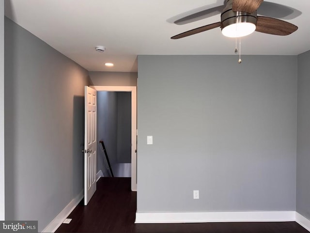 spare room with dark hardwood / wood-style flooring and ceiling fan