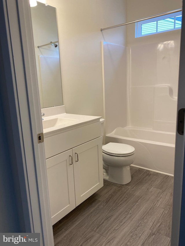 full bathroom featuring shower / tub combination, toilet, vanity, and hardwood / wood-style flooring