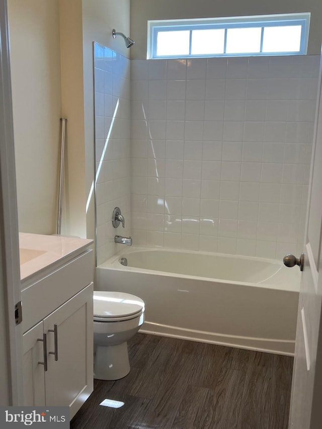 full bathroom with hardwood / wood-style floors, vanity, and a healthy amount of sunlight