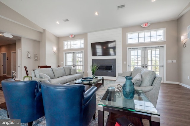 living room featuring a large fireplace, french doors, wood-type flooring, and plenty of natural light