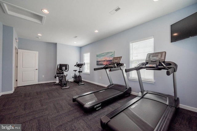 workout area featuring dark colored carpet and a wealth of natural light