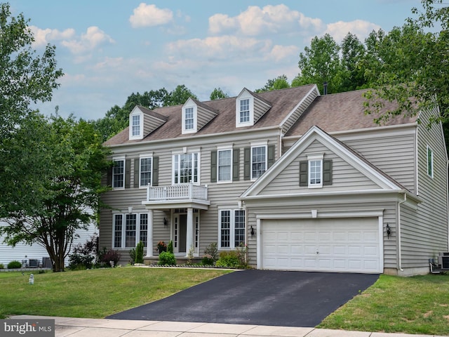 view of front of property with a balcony, a garage, and a front lawn