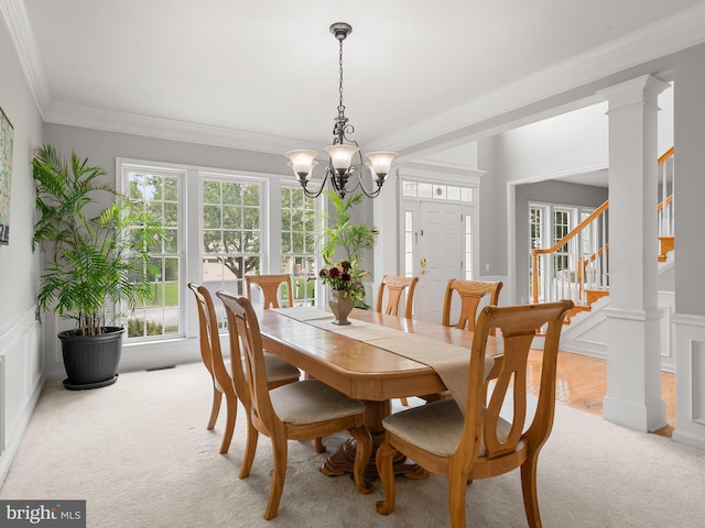 dining area with a notable chandelier, crown molding, and light carpet