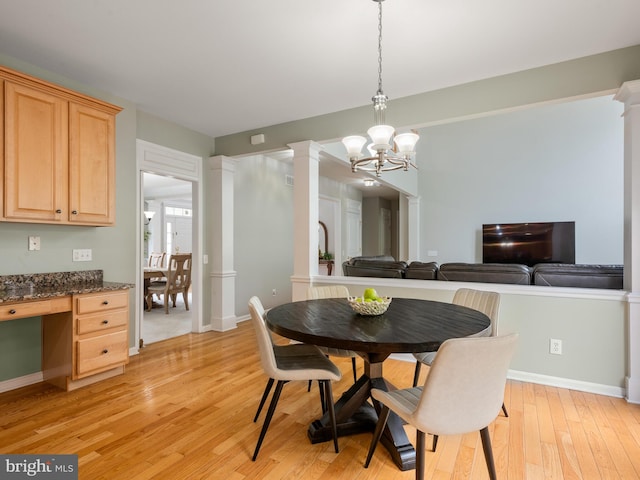 dining space with light hardwood / wood-style floors and an inviting chandelier