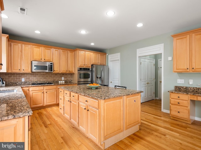 kitchen featuring sink, a center island, stainless steel appliances, and light hardwood / wood-style flooring