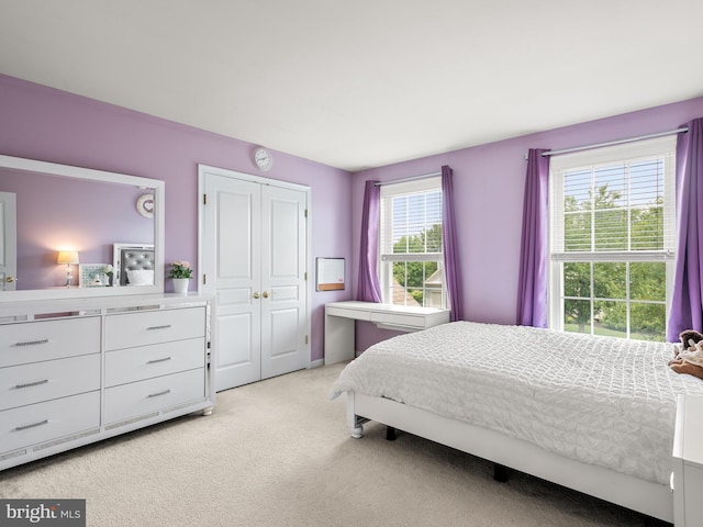 carpeted bedroom with multiple windows and a closet