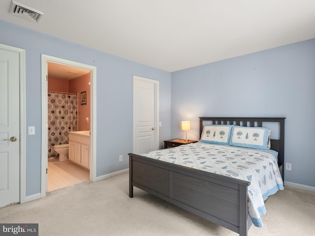 bedroom featuring light carpet and connected bathroom